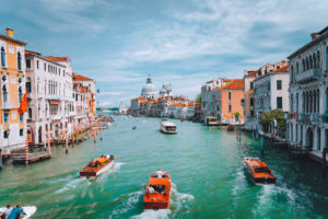 Venice, Italy. Tourist boats in Grand Canal with Basilica Santa Maria della Salute view in background. Venice, Italy. Tourist boats in Grand Canal with Basilica Santa Maria della Salute view in background.